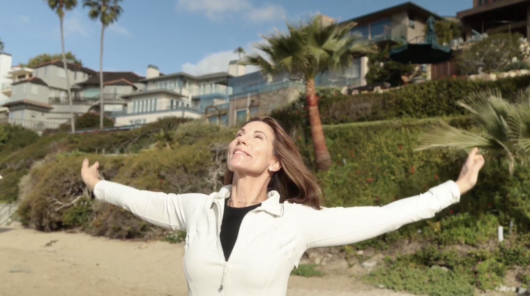 Alicia Gilbert opening her arms on the beach in Laguna